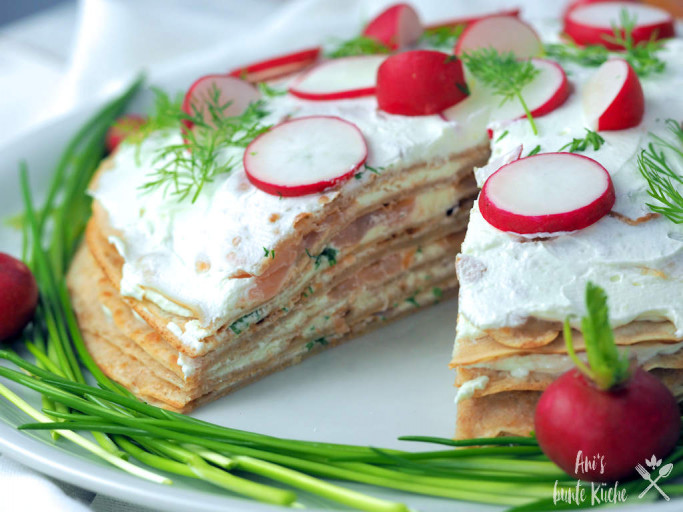 Schichten der angeschnittenen Lachs Crepes Torte auf Schnittlauchbett